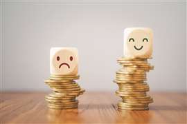 A small pile of coins with a sad face on top and a big stack of coins with a happy face on top